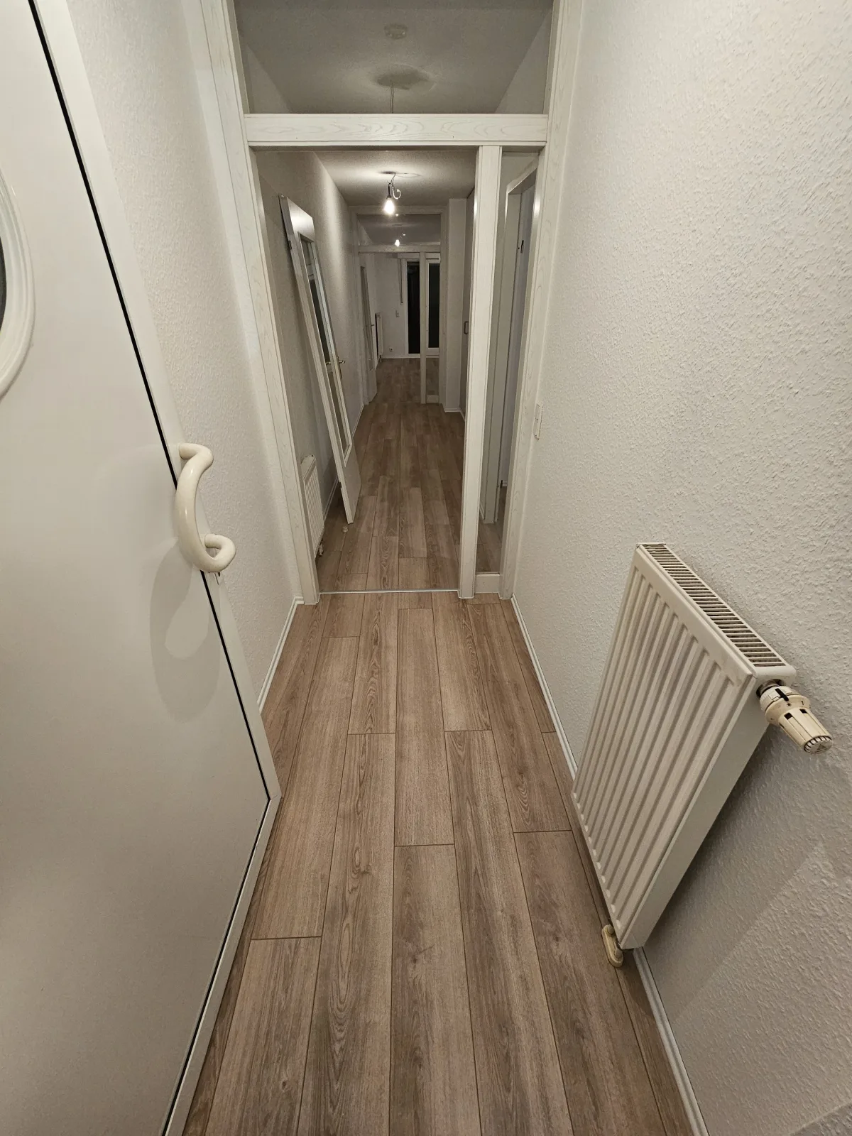 Derselbe Flur mit neu verlegtem Holzboden in Eichenoptik nach der Bodenverlegung