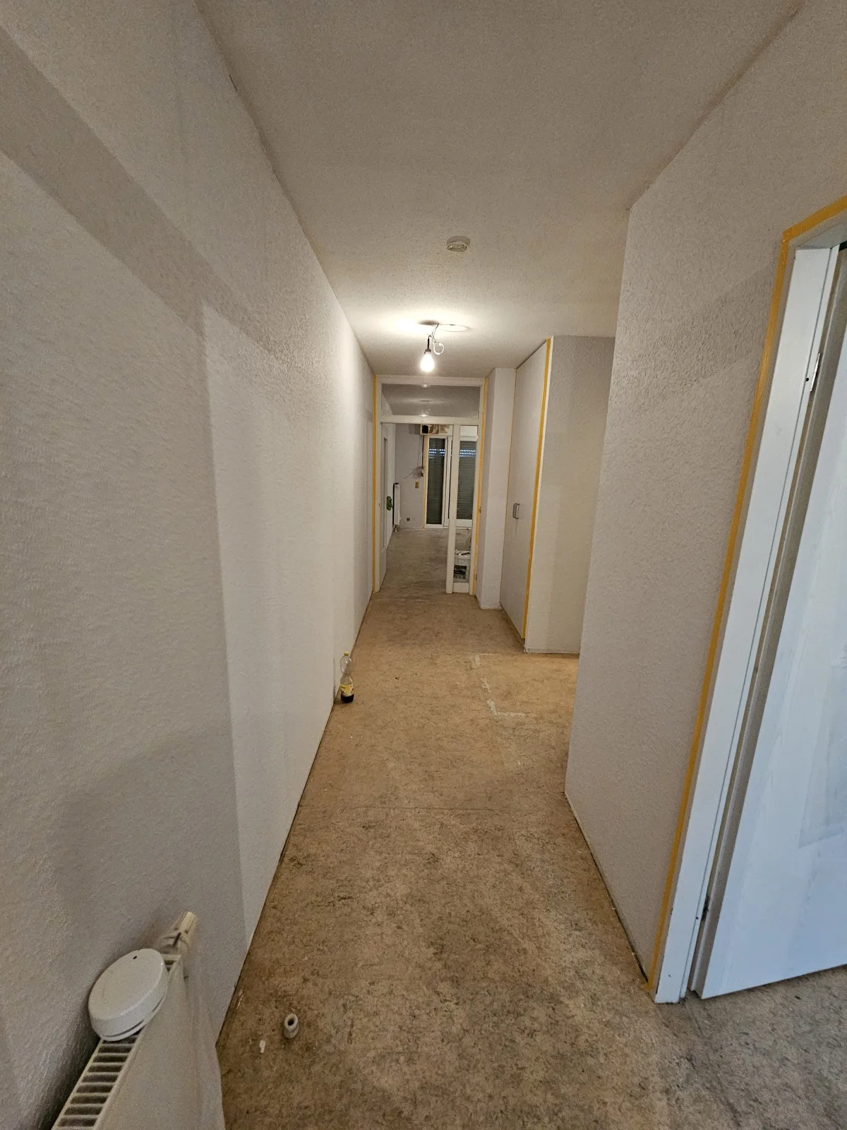 Flur mit rohem, unverlegtem Untergrund vor der Bodenverlegung