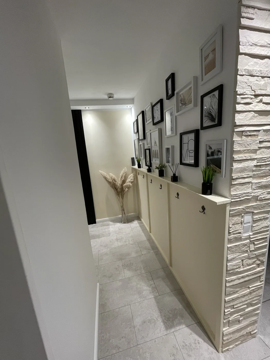 Dieselbe Nische fertig ausgebaut mit gestalteter Galeriewand, Sideboard und Steinwand nach dem Innenausbau