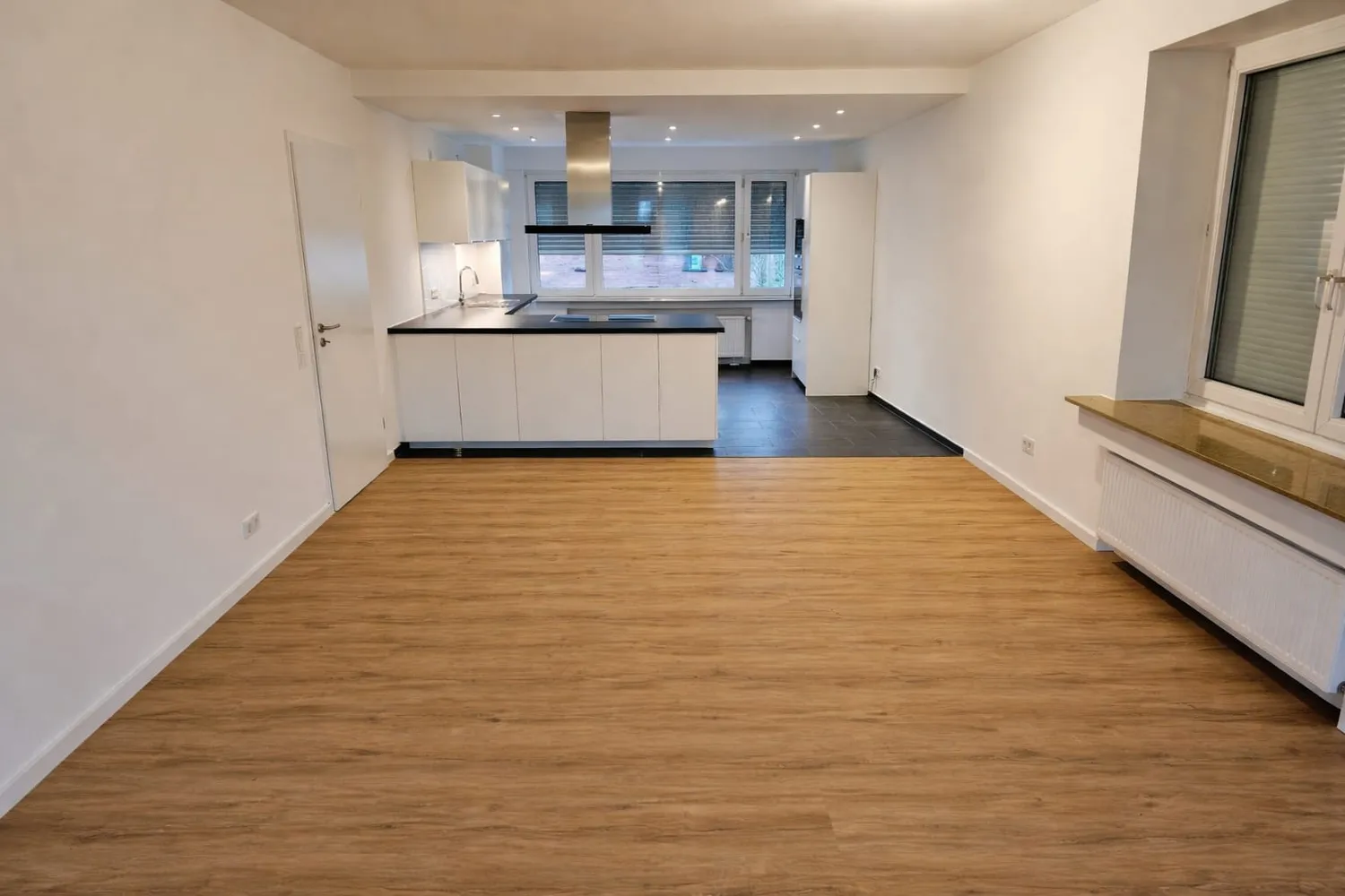 Fertig sanierter Wohnraum mit neuer Küche und Holzboden nach der Kernsanierung